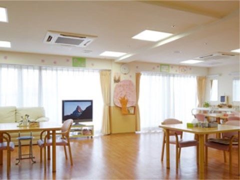 食堂の壁に、桜の木を模した作品が飾られた温かな雰囲気の食堂。テーブルとテーブルの間は広く開いている。