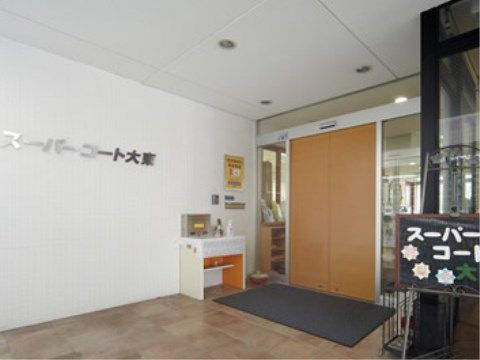 車椅子をご利用の方にも配慮した段差のないエントランスである。自動ドアの設置された入口の横には、手指用の消毒液が置かれている。