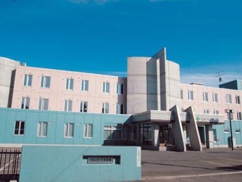 施設は、白色と水色で統一されたシンプルな外観となっている。入口には、施設名の書かれた門も設置されている。