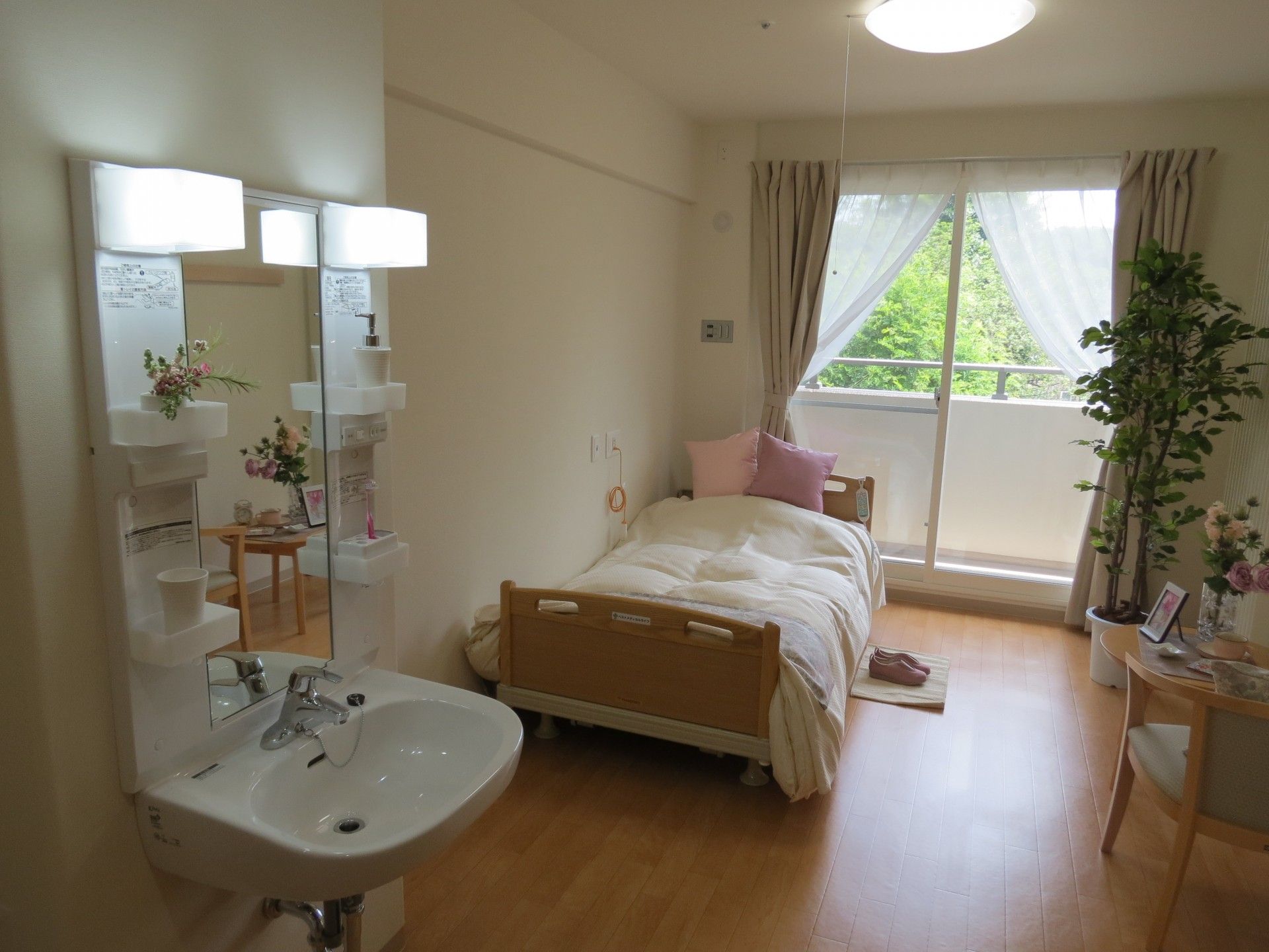白い壁で、フローリングの床の部屋である。トイレとフットレスの洗面台が付いている。トイレにはカーテン式の仕切りが付いている。