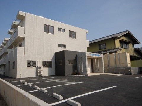 ３台分の駐車スペースを正面に構えた、３階建ての白い建物