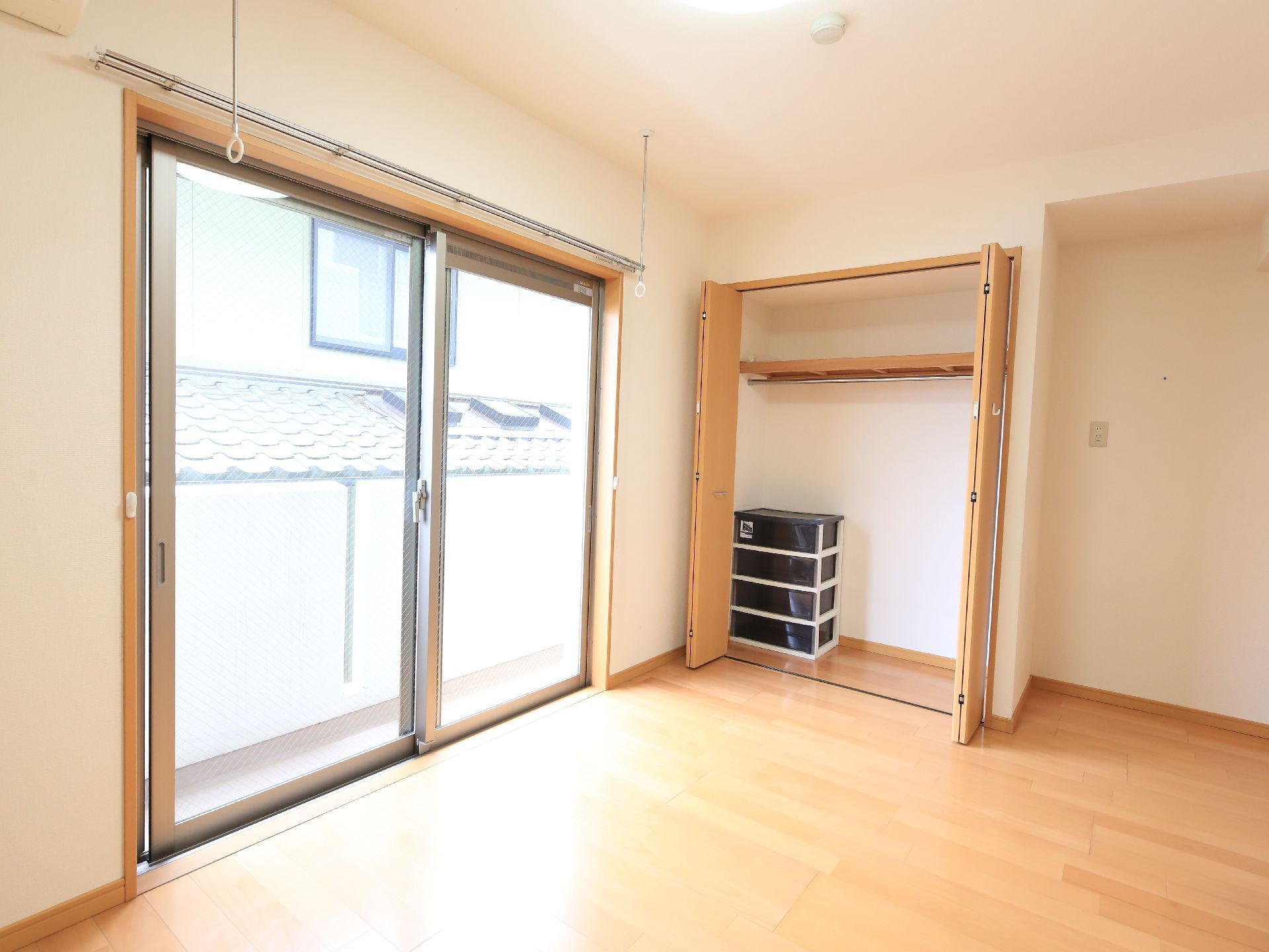 居室のクローゼットは壁に建つけになっている。窓辺にはカーテンレール、物干し竿用のバーが取りつけられている。