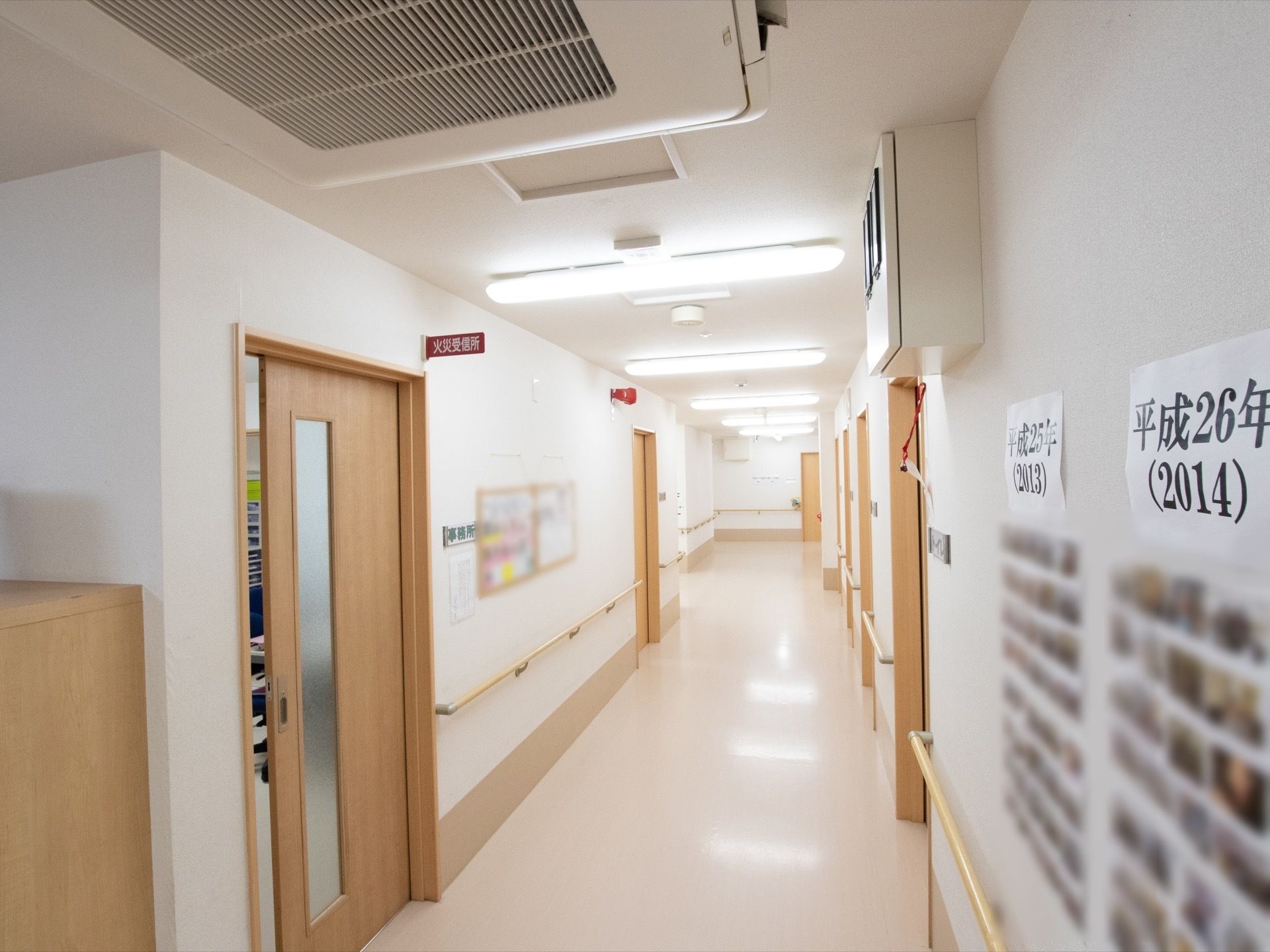 通路の左端に火災受信所があり、出入口のドアが少しだけ開けてある。その隙間から、ファイルケースなどが置いてあるのが見える。