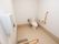 ベージュと白でまとめられた落ち着いた雰囲気のトイレである。温水洗浄機能付きトイレの横には、緊急用呼び出しボタンがある。