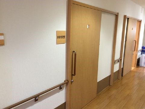 ドア横に木製の表札が取り付けられている、居室へ続く引き戸