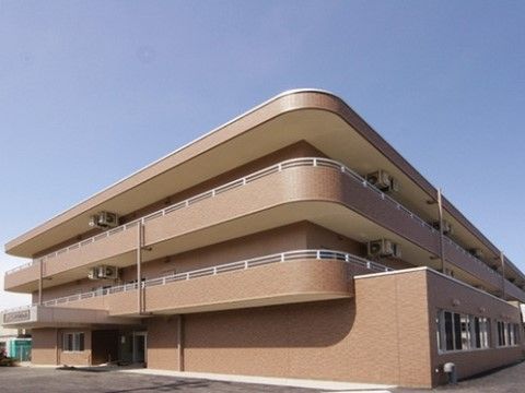 茶色の壁がすっきりとした印象を与える外観。２・３階の居室にはバルコニーが張り巡らされており、景色を楽しむこともできる。