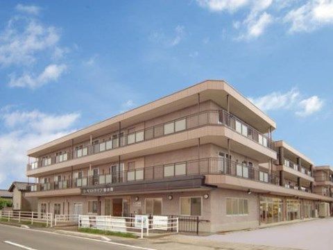ライトベージュの外装が落ち着いた印象を与えるマンションタイプの建物。施設の周辺は空間にゆとりがあり、段差が少ない。
