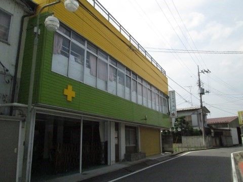 健康の郷 すみれの外観。緑色と黄色の壁面。