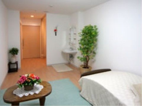 清潔感のある白い壁に、床はフローリングである。部屋内にはベッドやテーブルなどの家具が置かれ、洗面台はフットレス仕様である。