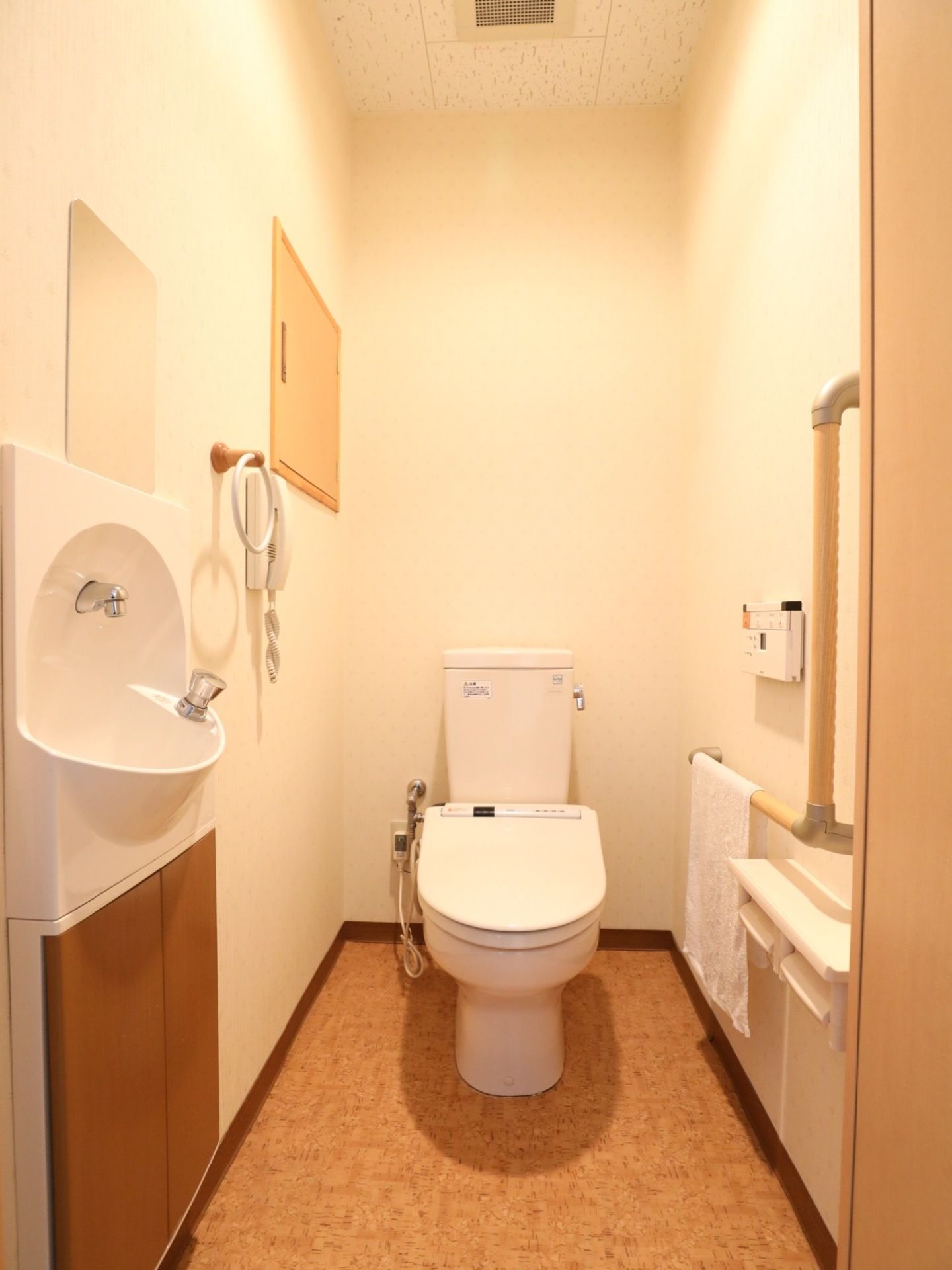 広々とした利用しやすいトイレには温水洗浄便座が完備されている。L字型の手すりも取り付けられ、洗面台がすぐ隣にあり便利である。