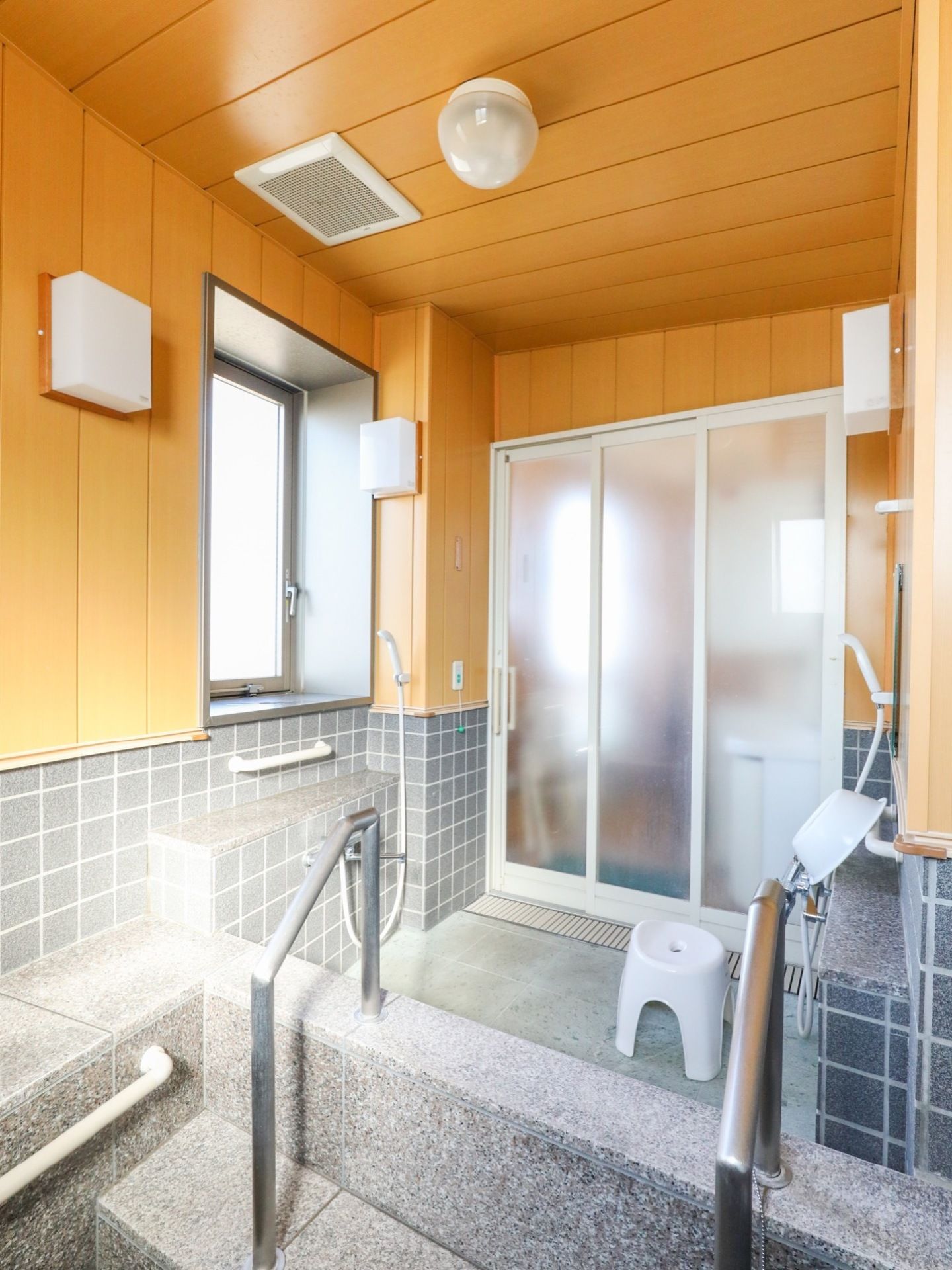 浴室は温泉風の構造で、壁や天井は木やタイルを使用し浴槽は石材を用いている。手すりや窓が取り付けられている。