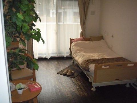 ベッドは高さと頭側の角度調整ができるものになっており、起き上がりを助ける。枕元には緊急時用のナースコールが設置されており、安心である。