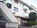大きなマンションのような外観。各部屋にバルコニーがついている。入り口前には屋根のついた休憩所が設置されている。