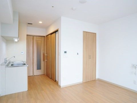 廊下へ続くドアの両側にキッチンとトイレへの引き戸がある居室