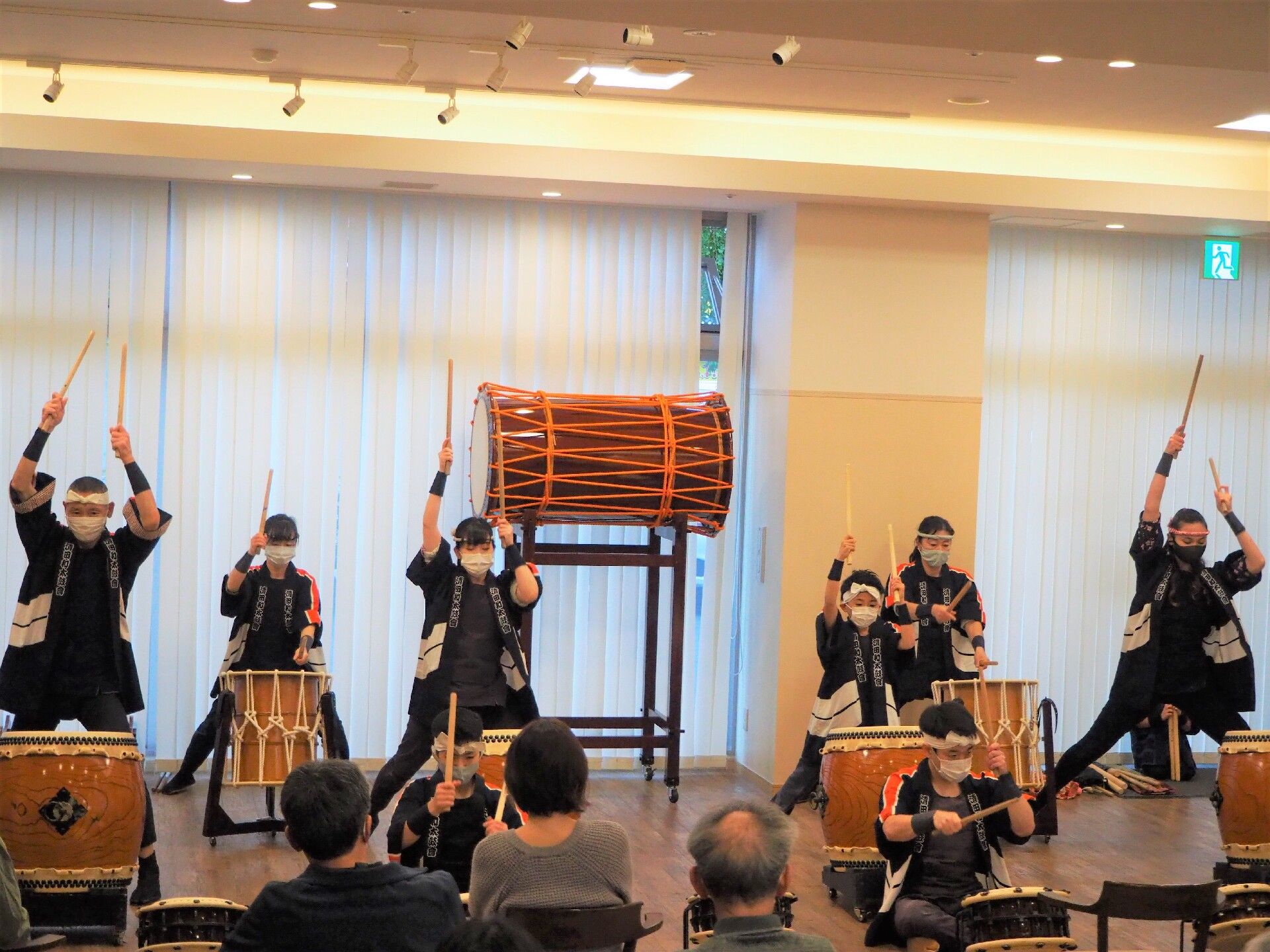 椅子に座った入居者様の前で和太鼓を叩くたくさんの演者