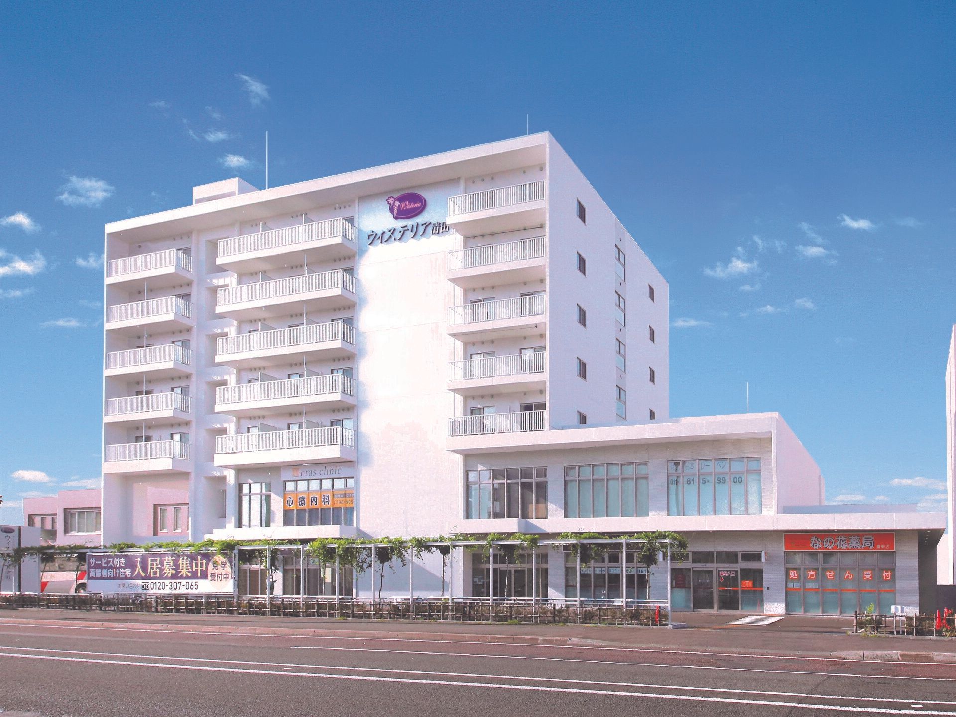 大通りに面した場所に建てられた白いマンションのような雰囲気の建物