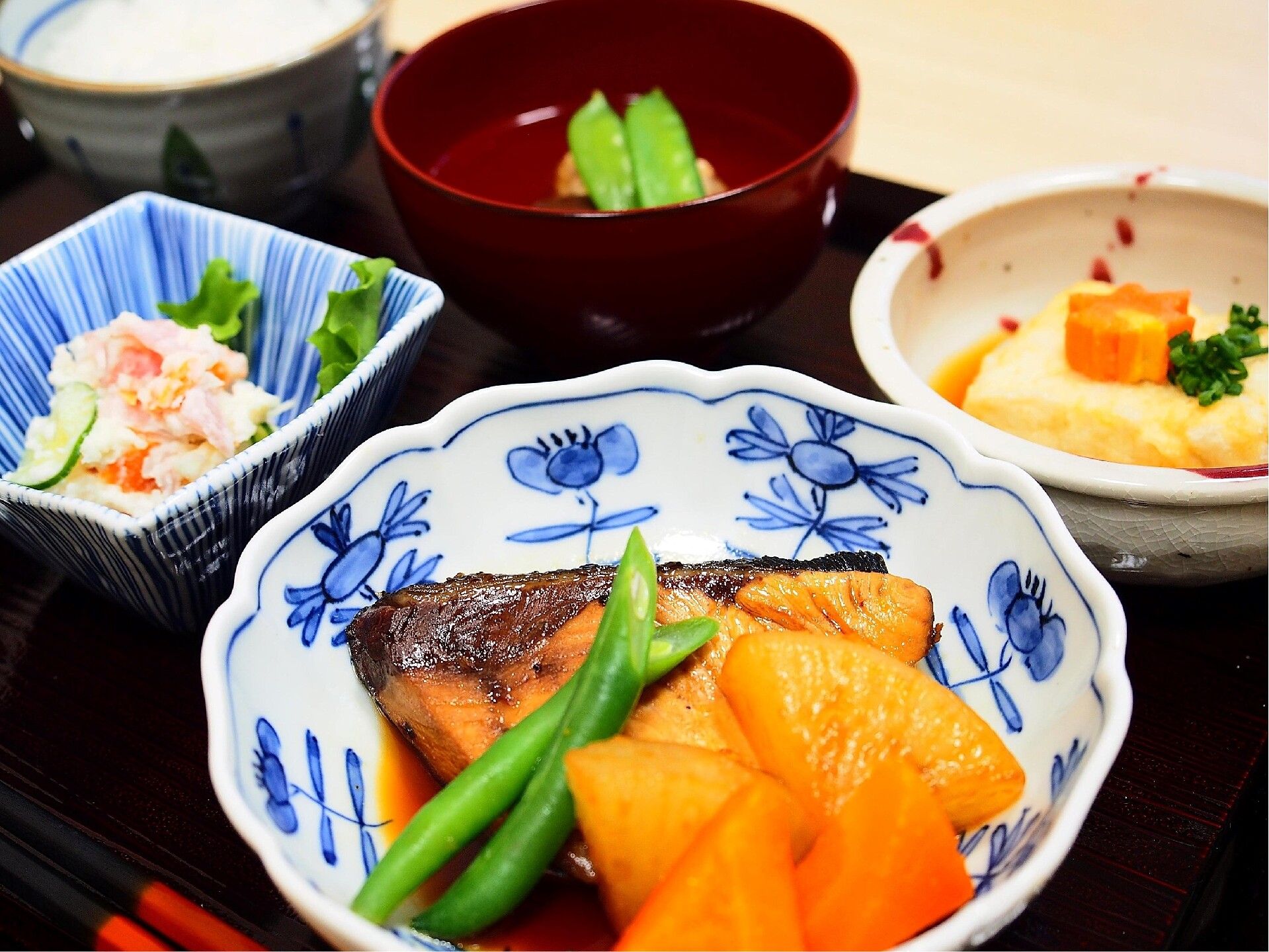 魚や野菜の煮つけや汁物がセットになった食事