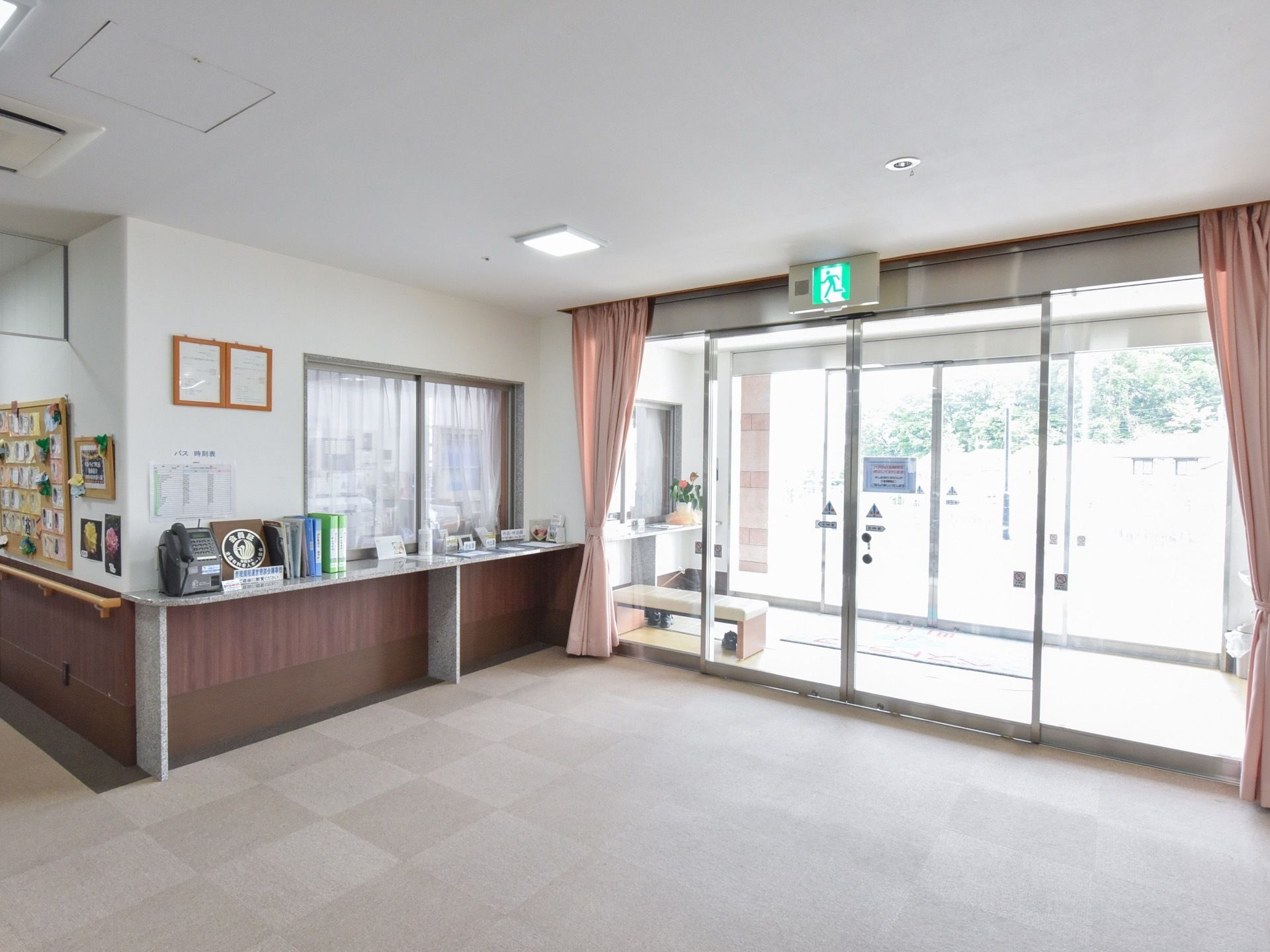 自動ドアが二重に設置されている玄関である。ガラス製で外からの光が入る明るく広々としたスペースである。