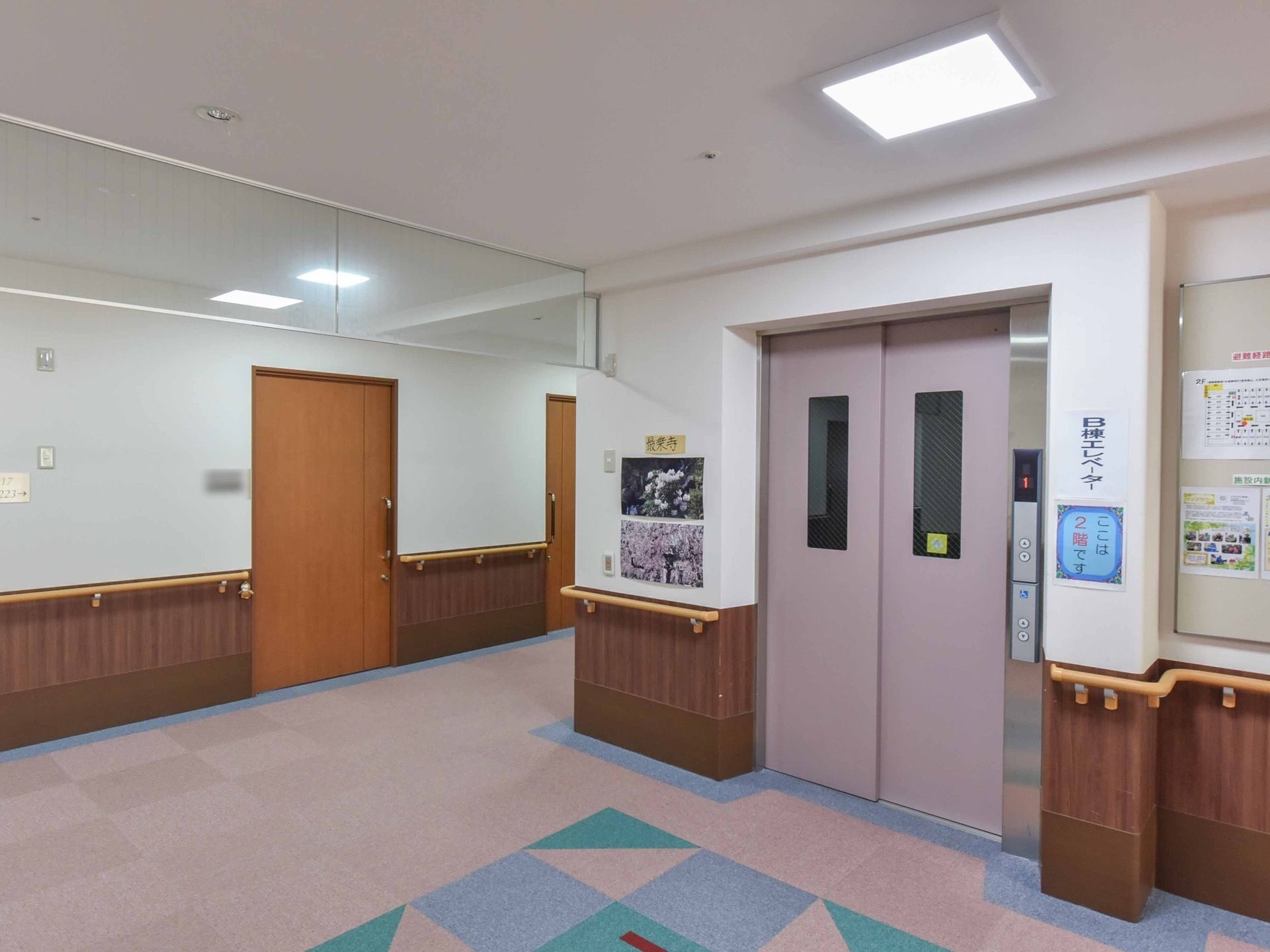 エレベーターを１基設置しており、薄い紫の扉になっている。車椅子をご利用の方が安全に階の移動をすることができる。