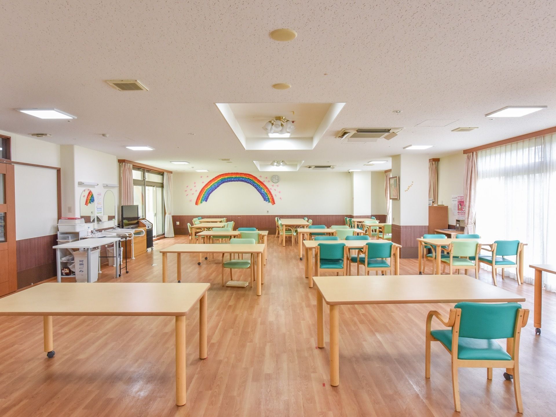 広い共有スペースの天井にはエアコンが設置されており、快適に過ごすことができる。テーブルと椅子をゆったりと配置しており、くつろぐことができる。