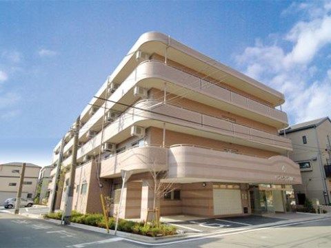 ピンクのボーダーの柄で、ベランダがカーブを描いた優しい外見の建物である。玄関の屋根に施設名が表示されている。