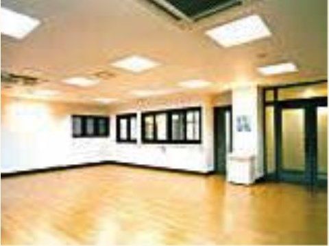フローリングの床の広い部屋で、白い壁に黒色の窓枠やドアがアクセントとなっている。照明がたくさん付いている。