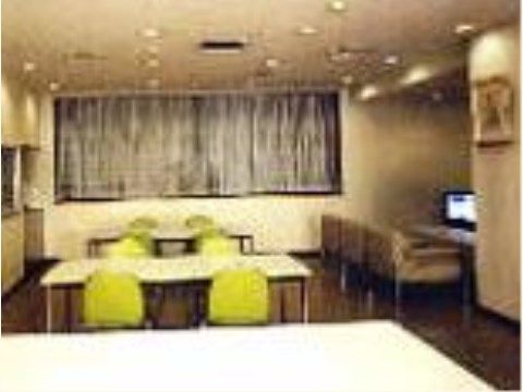 落ち着いた印象の室内に、テーブルや椅子が置かれている。部屋の奥のカウンターにはテレビとソファも備わっている。