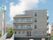 明るめのグレーの外壁が爽やかな印象の4階建ての建物。２階から４階の居室部分にはベランダも設置されている。