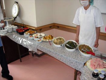 長机にバイキング形式のさまざまなメニューが並べられた様子