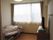 大きな窓のある部屋にベッドが置かれている。エアコンが設置されているので、年間を通して快適な生活を過ごすことができる。