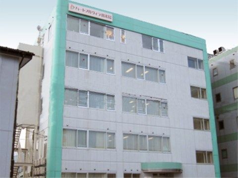 最上階の外壁に施設名の書かれた看板が設置されているビル