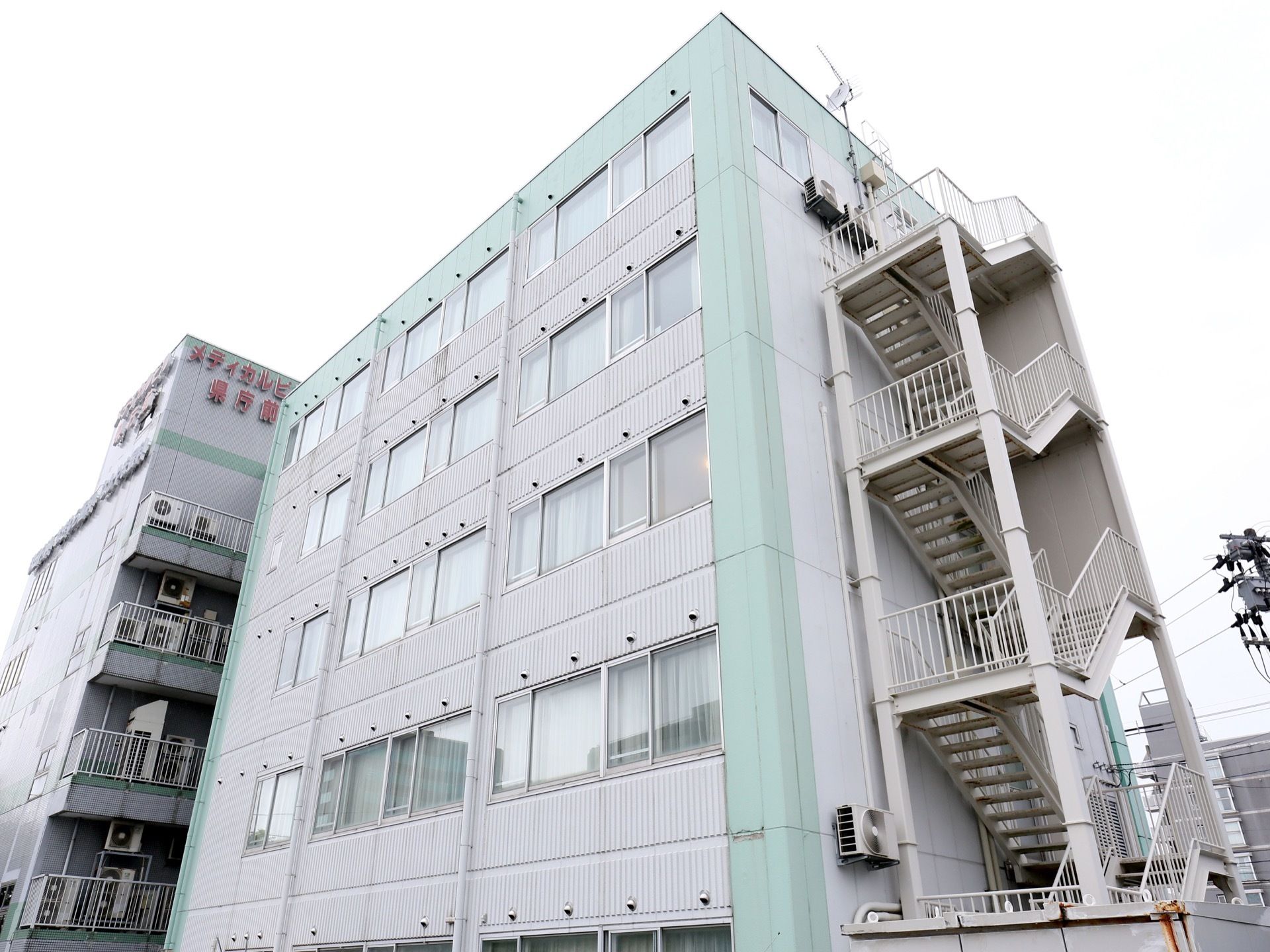 施設は白い5階建ての建物である。建物の右端に外壁に沿って外階段が設置されている。市街地の中心部に位置している。