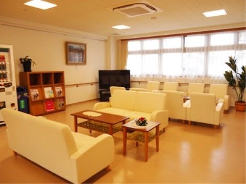 １人用や２人用の白いソファが並べられた共有スペース
