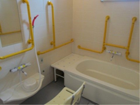 お一人でも安心して入浴を行えるように、壁にたくさんの手すりを完備している。洗い場の前には椅子を置いている。