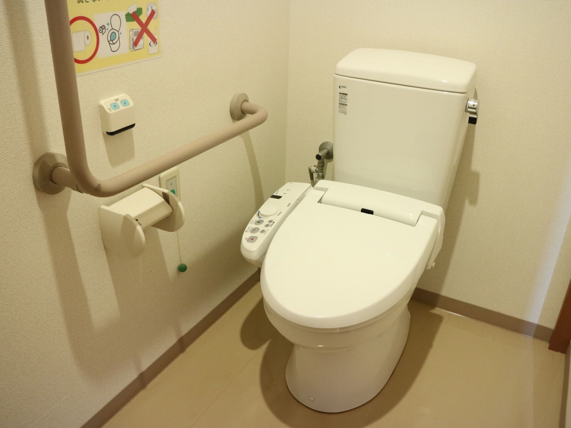 清掃が行き届いたきれいなトイレの壁には、Ｌ字型に手すりが設置されている。立ち座りの際に掴まって体を支えることができる。