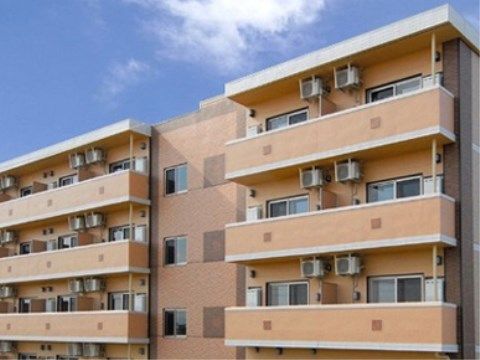 室外機が設置されたベランダが並んでいる建物の高層階部分