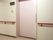 廊下の一角に共用のトイレがある。扉は薄いピンク色で、引き戸になっている。近くの壁には手すりが設置されている。