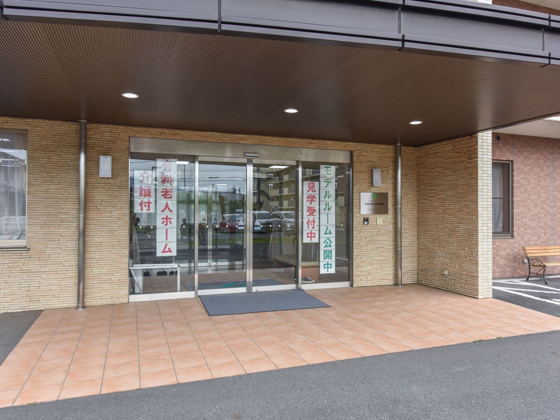 玄関ポーチに屋根が張り出し、屋根の下まで車を寄せることができる。玄関扉はガラスの自動扉になっている。