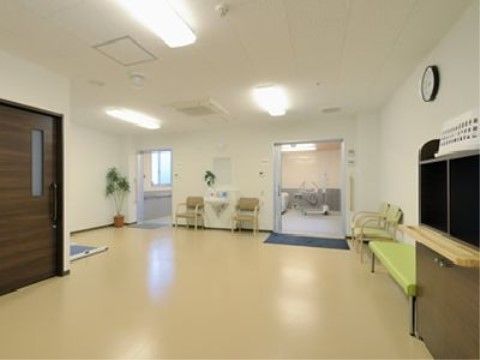 明るい空間の脱衣室である。その壁際には椅子が設置されており、入居者様は入浴後しばし休憩することも可能である。