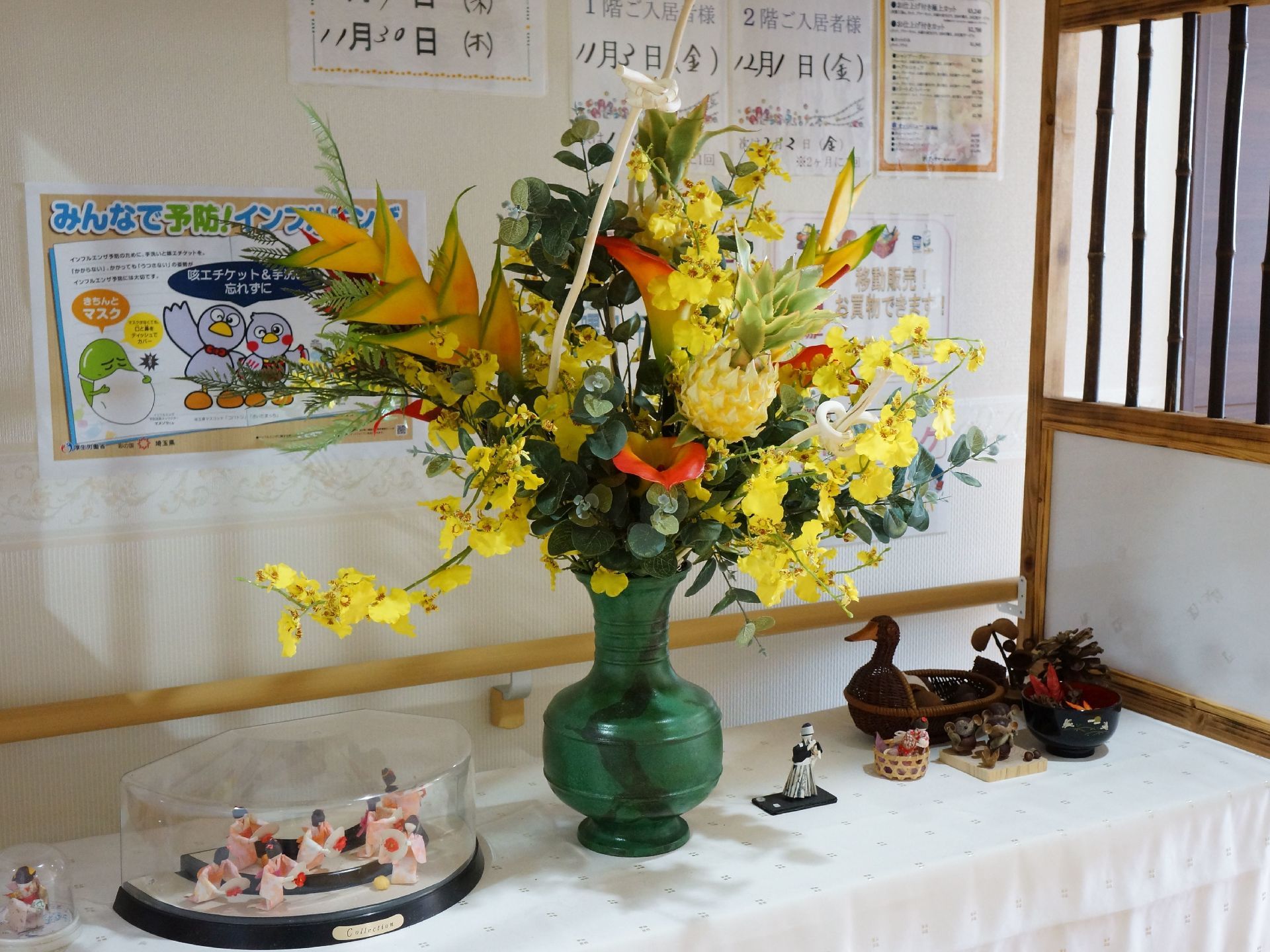 グループホームには、イベントの案内や告知などをおこなう掲示板を用意している。またフロアには、お花や小物などを飾っている。
