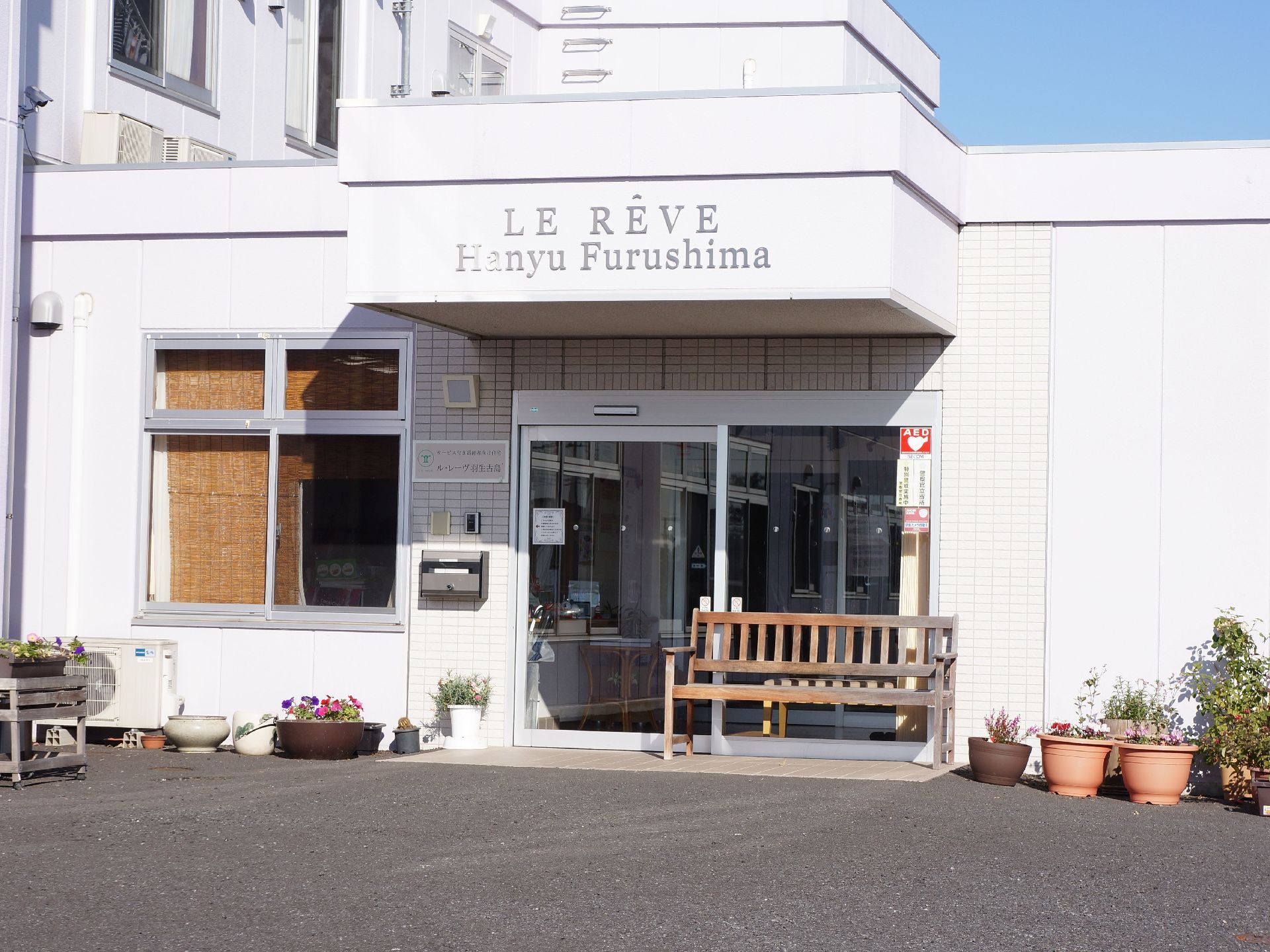 エントランスには自動ドアがあり、壁にインターホンが取り付けられている。また入り口にはベンチが置かれている。