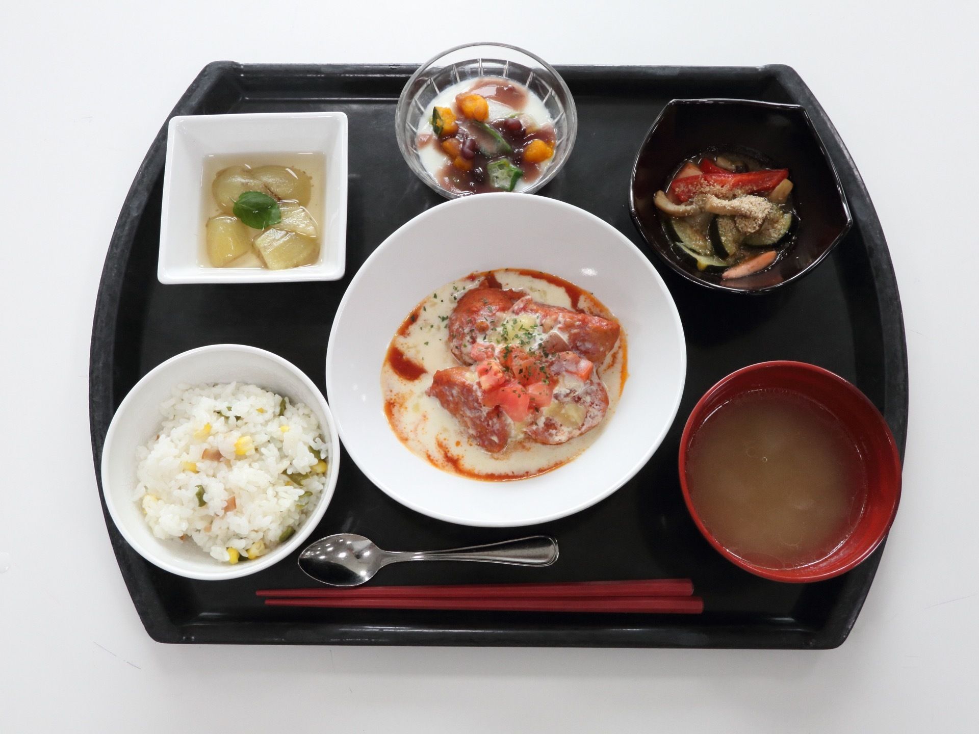 主菜はトマトのチキン煮込みで、なす、かぼちゃ、オクラなどの野菜をたっぷり使った副食が二品。栗の炊き込みご飯の他にデザートや汁物がある。