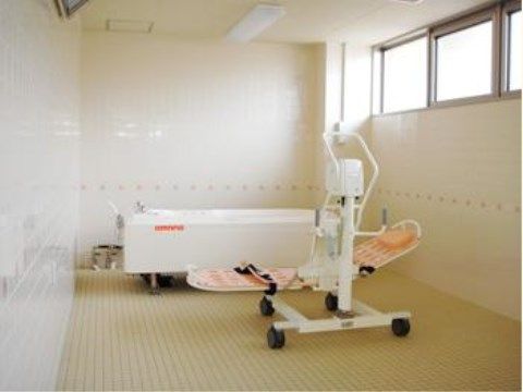 「ベストライフ甲府」の機械浴室。スタッフが介護サポートを行い、入居者様のお身体を丁寧に優しく洗い流す。