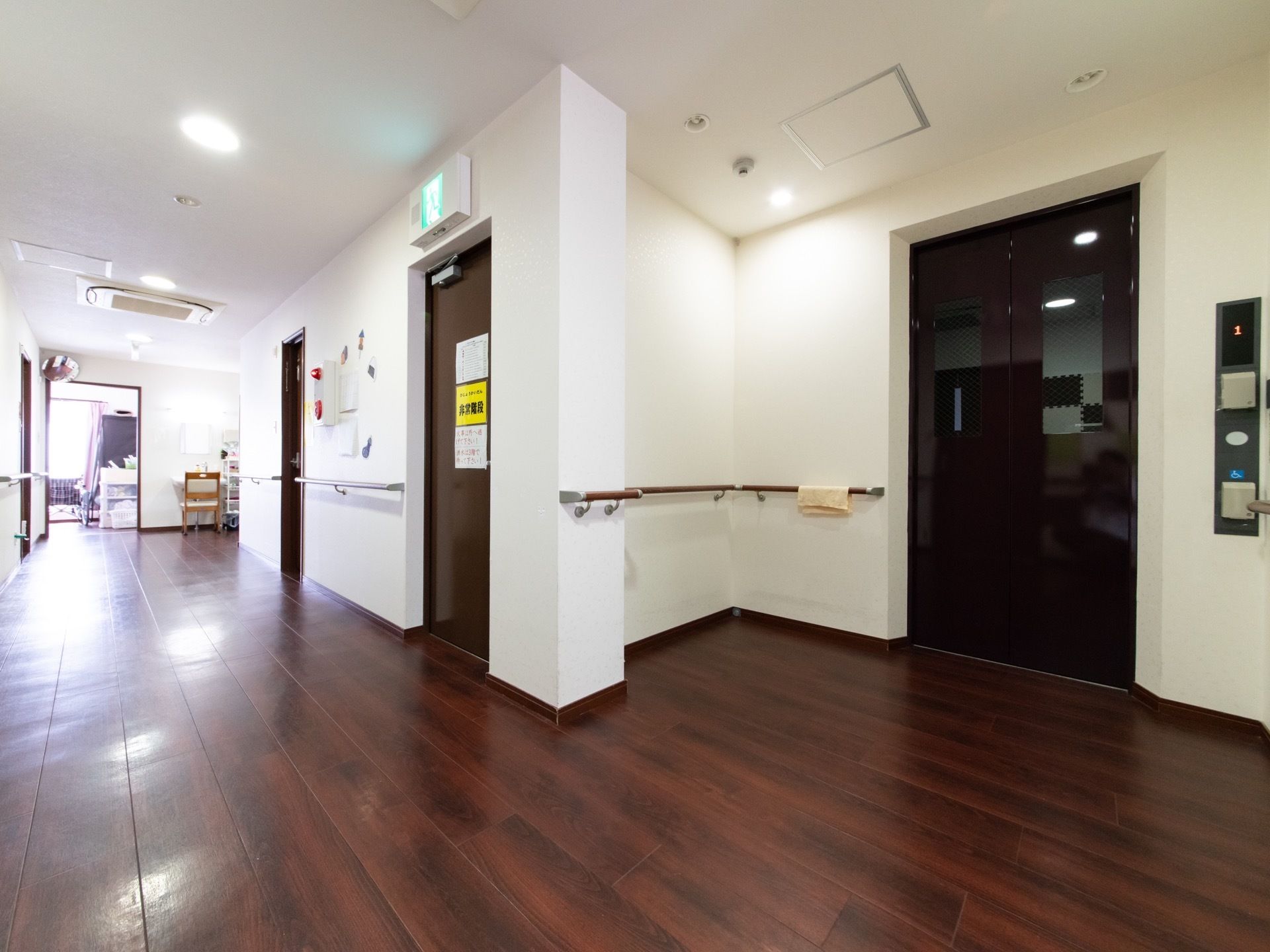 木目調の床であたたかみのある通路。足腰が不安な方のために、通路幅も広く手すりやエレベーターが設置してある。
