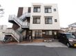 アットホームな雰囲気の3階建ての建物。玄関の近くに車を停めることができる。周りに高い建物がなく、日当たりが良い。