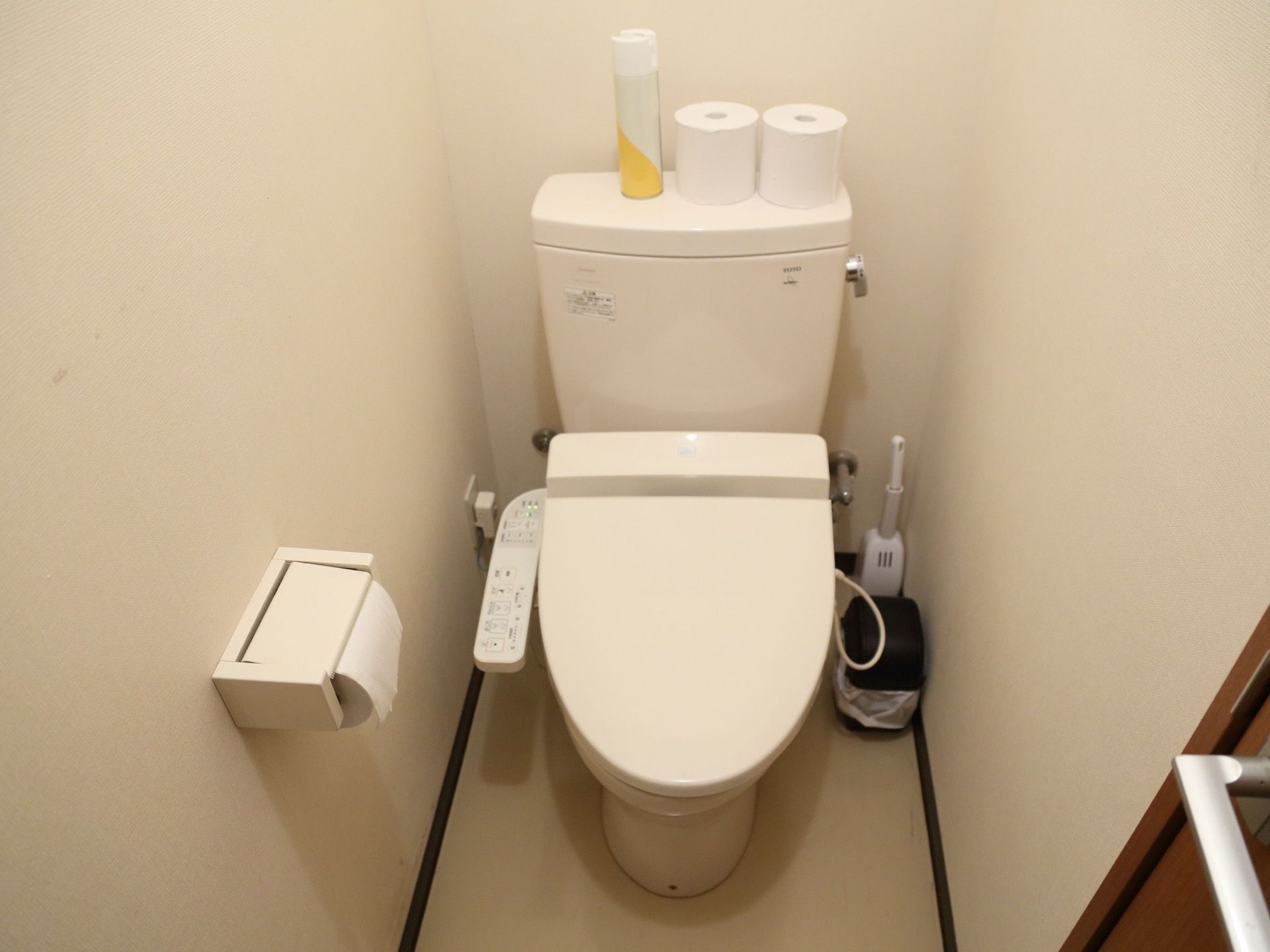 トイレ内は明るく、オフホワイトの調和のとれた壁で整えている。そばにはごみ箱が用意されている。温水洗浄便座である。