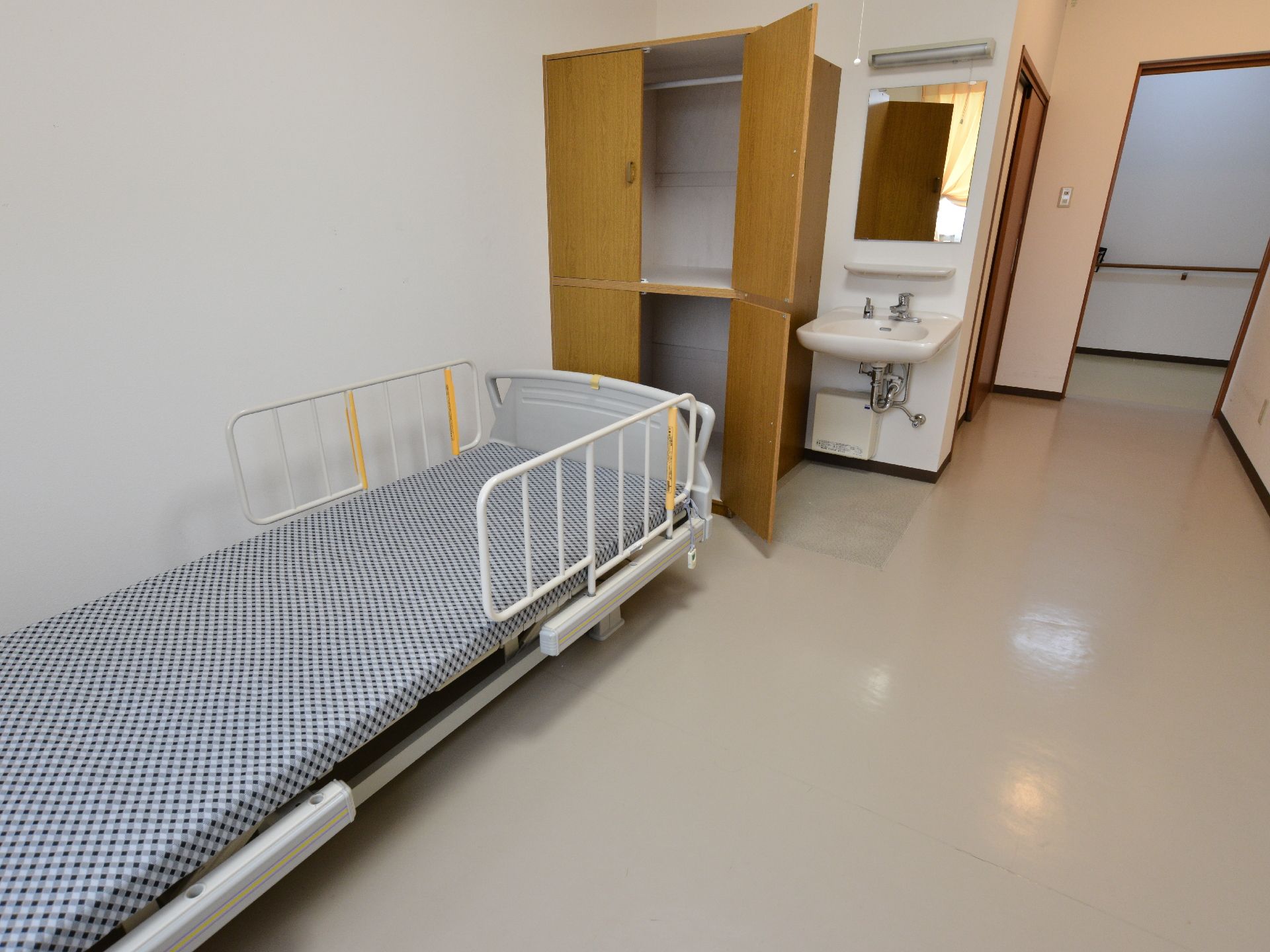 1人部屋の例。ベッドの半面には取り外し可能な柵がある。2段に分かれたクローゼットがある。その横には手洗い場があり、鏡とカウンターも完備。