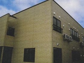 「ふるさとホーム前橋三俣」の外観。2階建てのベージュ色のタイルが目印の、サービス高齢者向け住宅である。