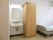 奥の部屋にベッドが見える。エアコンがついている。寝ながら電気を消すことができるように、ひもが長めである。