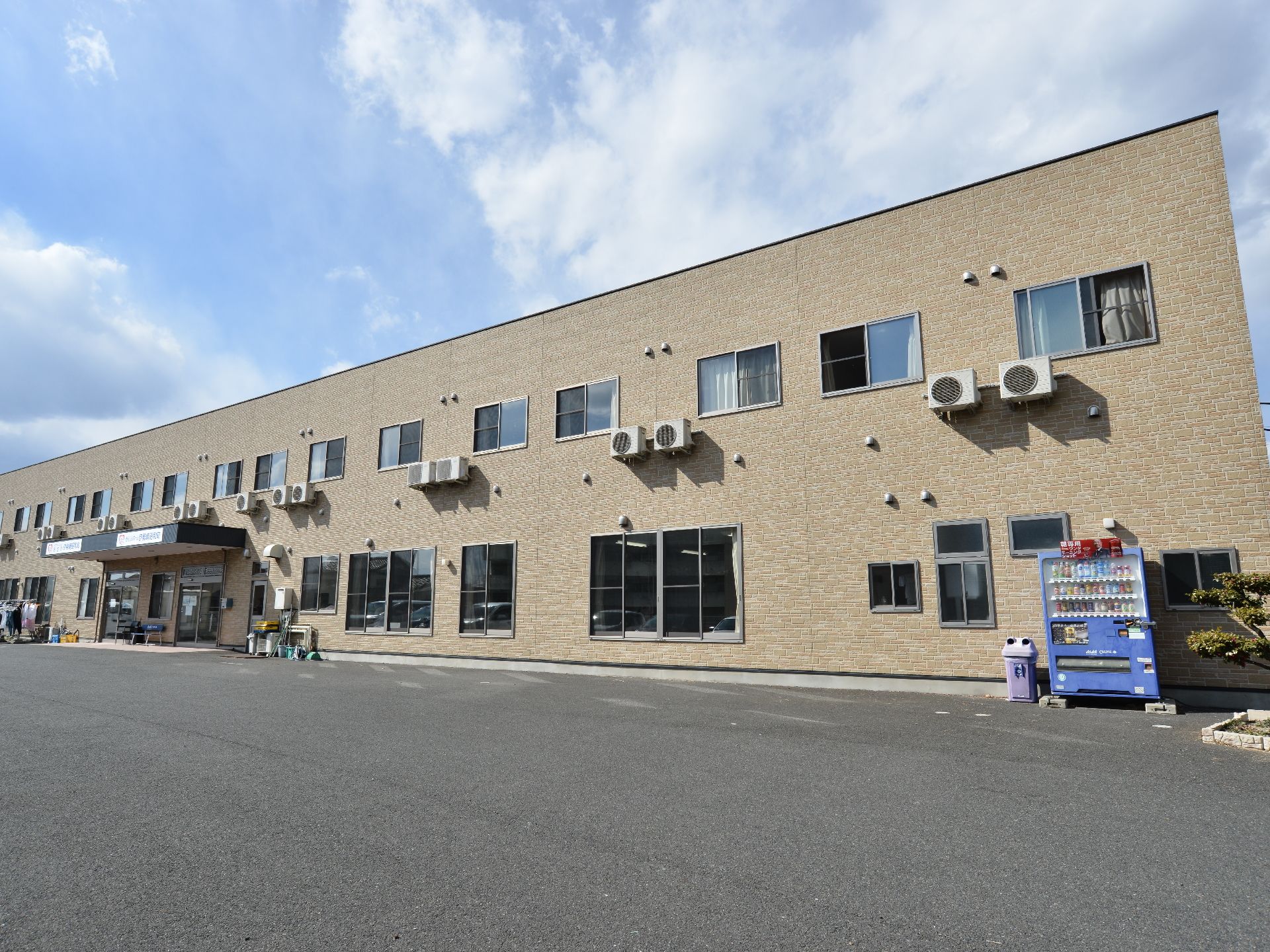 長四角でクリーム色の2階建ての建物になっている。手前はコンクリートで舗装されており、入り口は中央付近に位置している。
